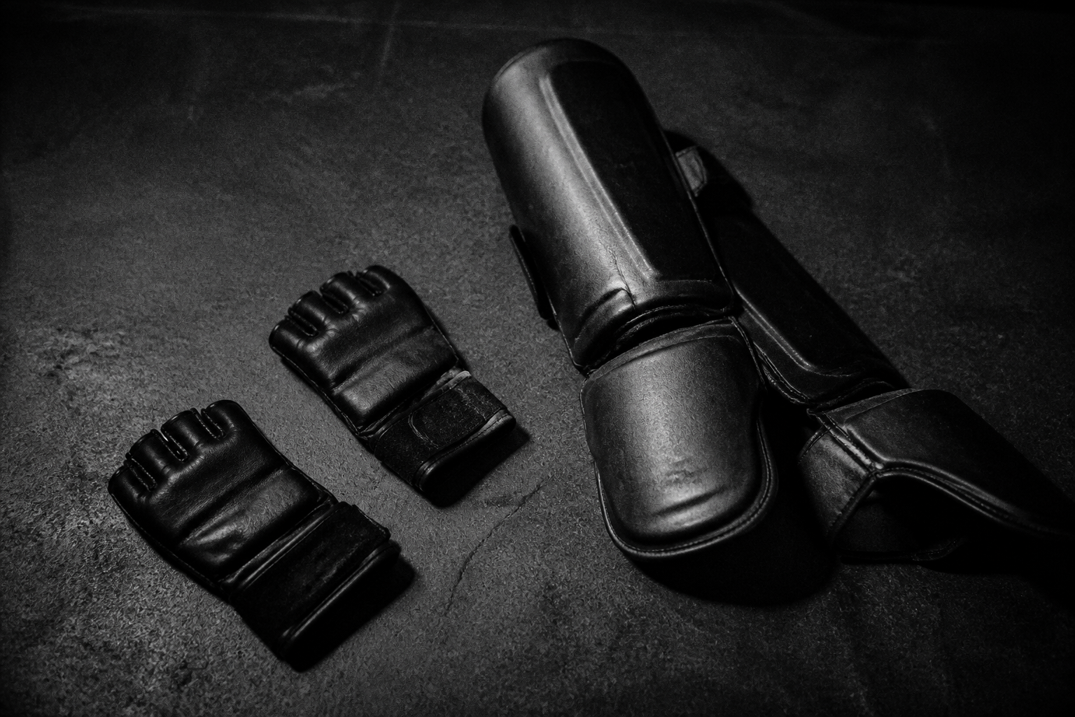 Otwarte rękawice MMA i ochraniacze na ciemnym betonie