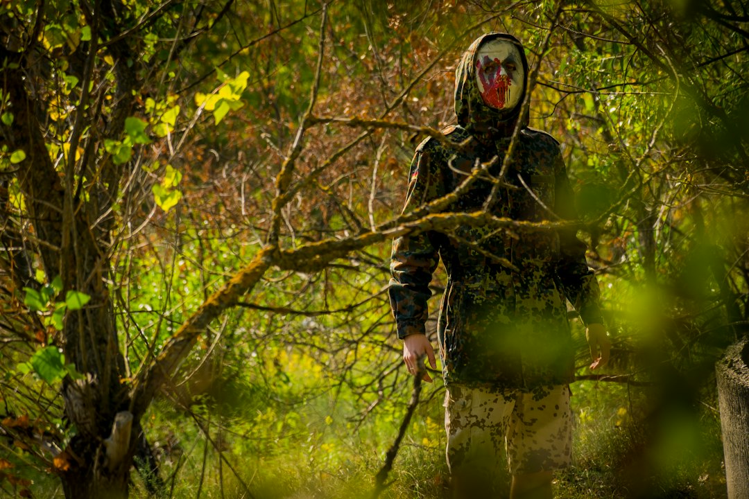 Maska i marker paintballowy na leśnym podłożu